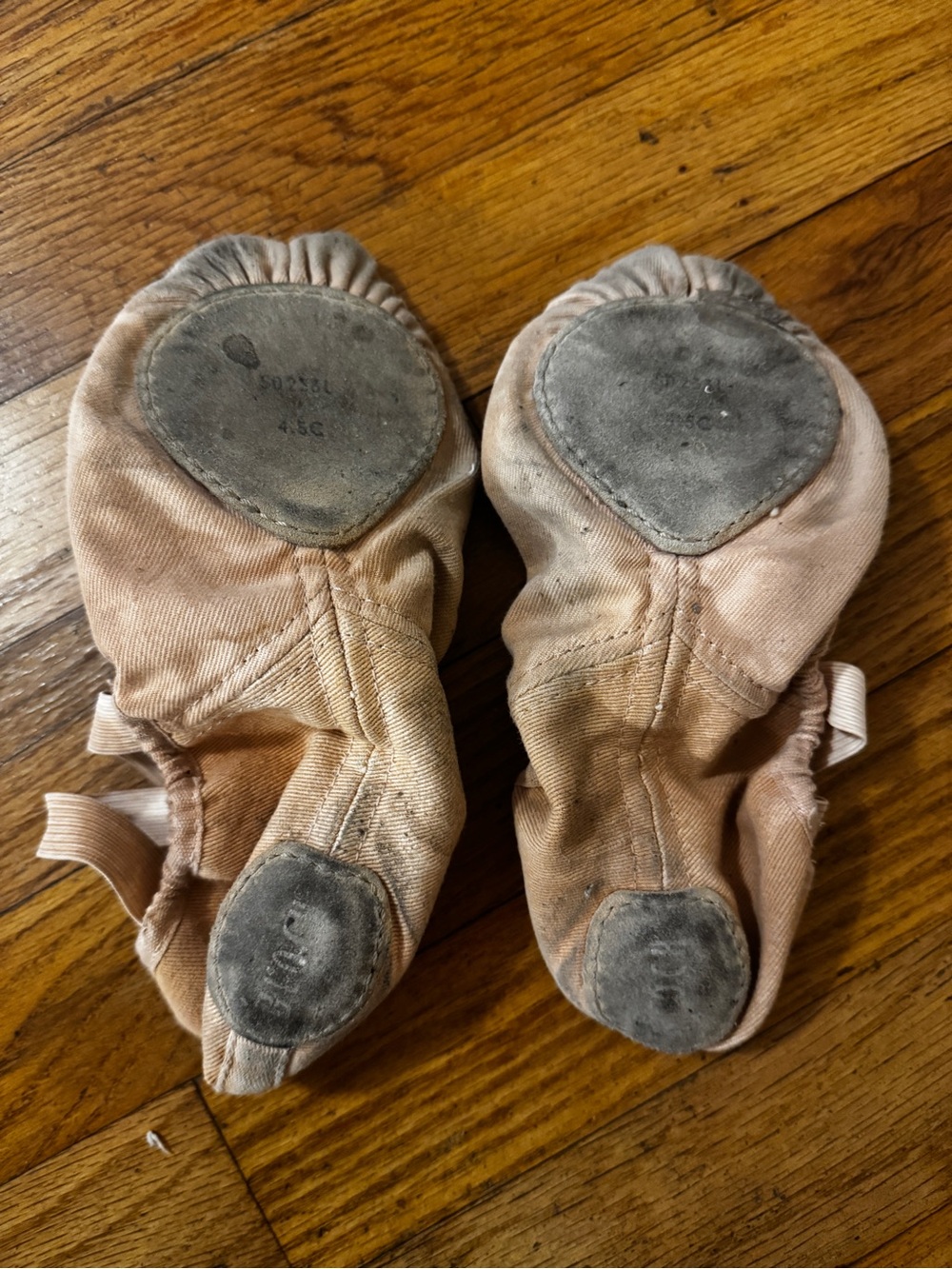 Well worn tan flat ballet shoes